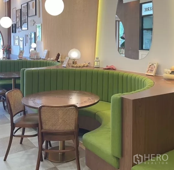 Retail Space for rent in Watthana, Bangkok - Curved green booth with round table and backlit wall mirror.