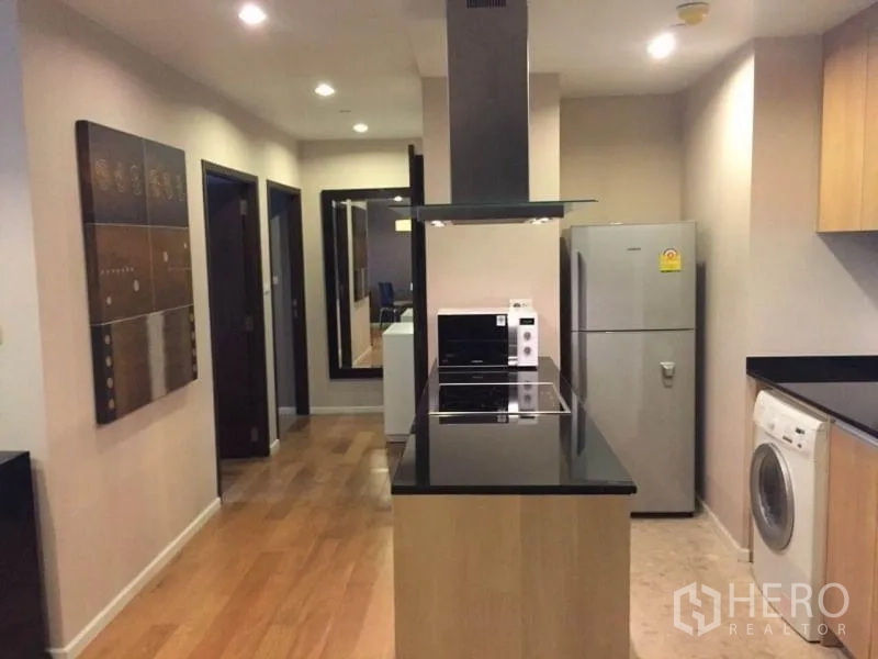 คอนโด ให้เช่าในSathon, Bangkok - ครัวสไตล์แกลเลอรี่ เคาน์เตอร์หินสีดำพร้อมเตาไฟฟ้า เครื่องดูดควัน ตู้เย็นสแตนเลส และเครื่องซักผ้า