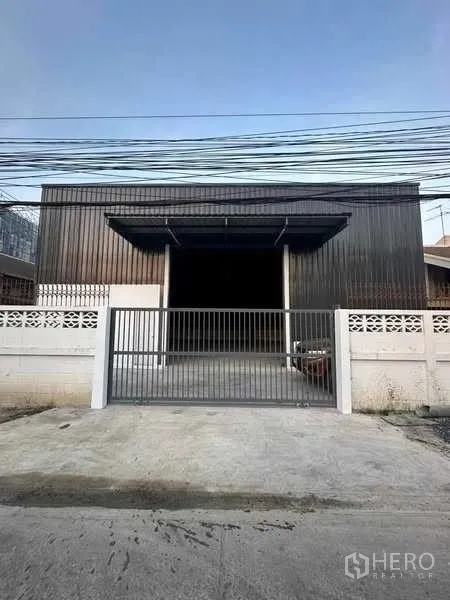 货栈 出租在Bang Khen, Bangkok - 临街仓库立面，双雨棚与安全滑动大门，前方混凝土铺面。