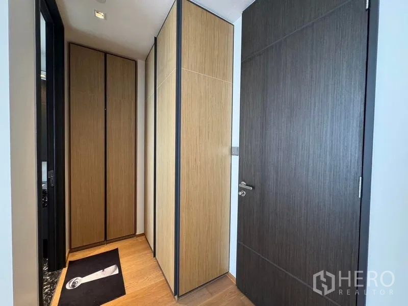 Condominium for rent - Entry corridor with built-in wood wardrobes and a dark accent door.