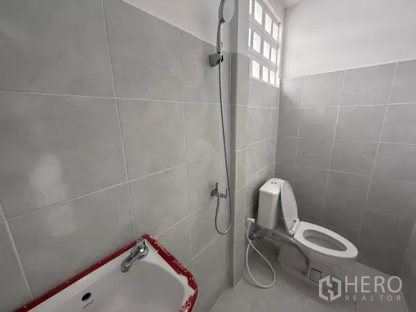 货栈 出租在Lat Krabang, Bangkok - 全新卫浴，瓷砖墙面，配淋浴、坐便与通风玻璃砖窗。