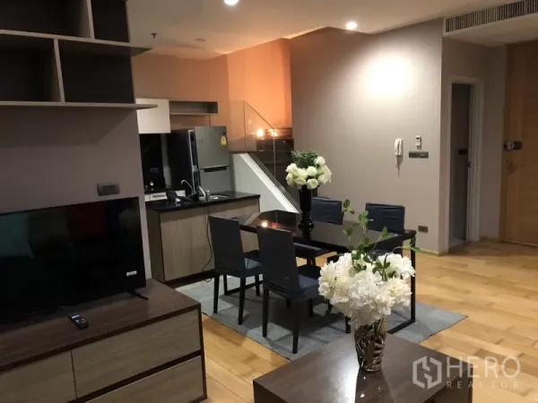 公寓 出租或出售在Khlong San, Bangkok - 开放格局，电视柜、岛台厨房、餐桌与木地板通向楼梯。