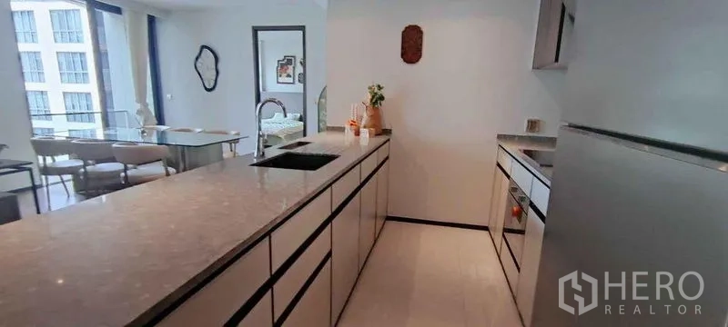 公寓 出租在Watthana, Bangkok - 现代走廊式厨房，长石质台面、洗槽、烤箱与冰箱。