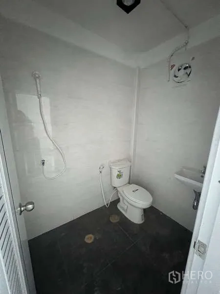 Shophouse for rent in Watthana, Bangkok - Second bathroom with shower, toilet, sink, and extractor fan.