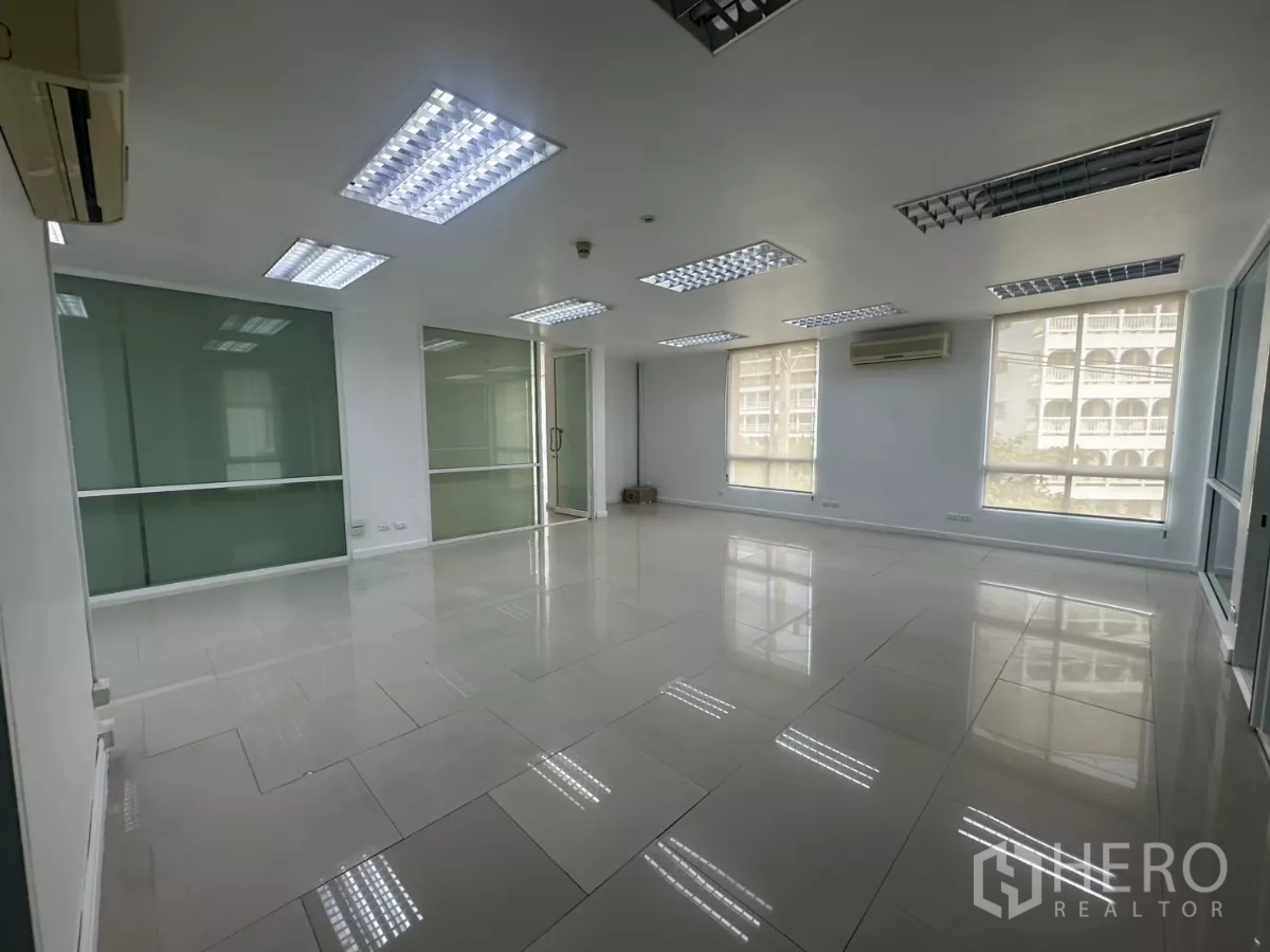 Office Space for rent in Huai Khwang, Bangkok - Main office room featuring large windows with blinds, grid ceiling lights and air conditioning.