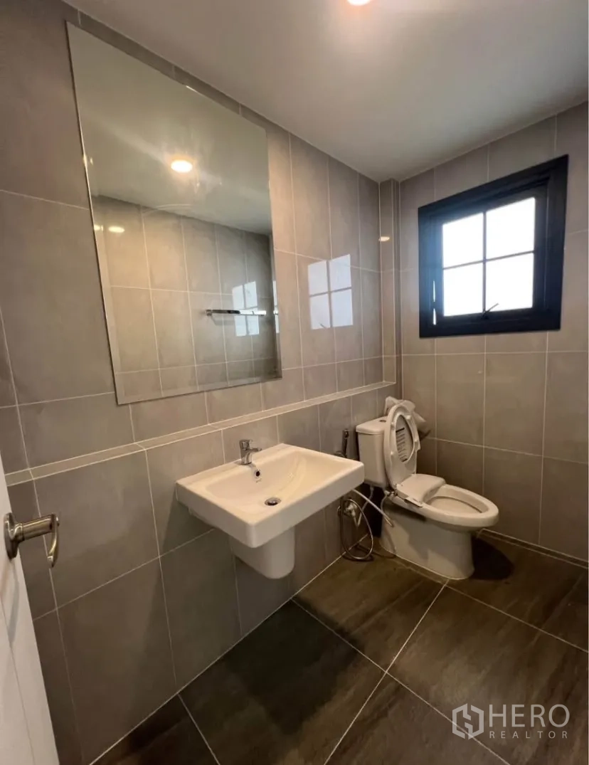独栋房屋 for rent in Bang Phli, Samut Prakan - 全瓷砖卫浴，设大镜子、台盆、坐便器及窗户。