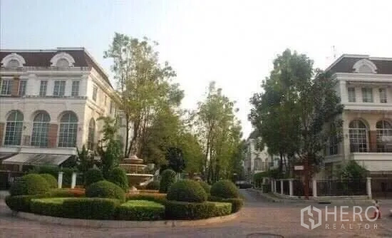 Townhouse for rent in Bang Kapi, Bangkok - Leafy private estate roundabout with trimmed hedges, fountain and classic townhomes.