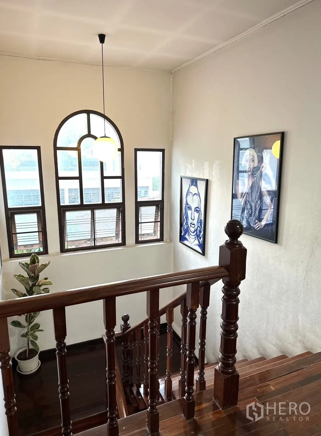 Detached House for rent in Saphan Sung, Bangkok - Upper landing with gallery wall and arched windows above the staircase.