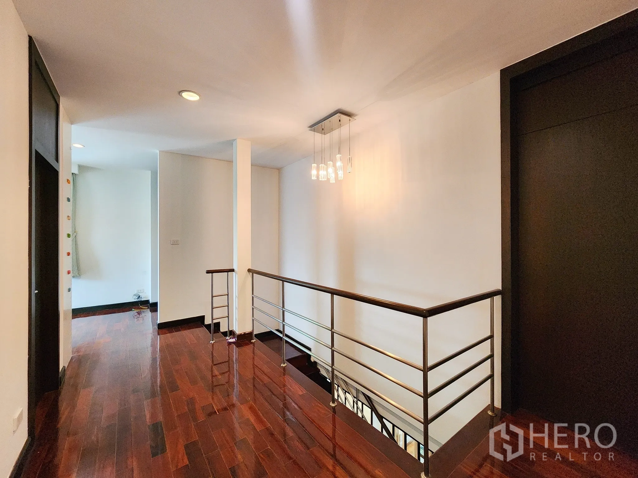 Detached House for rent in Bang Kapi, Bangkok - Upstairs landing with pendant light, handrail and hardwood flooring.