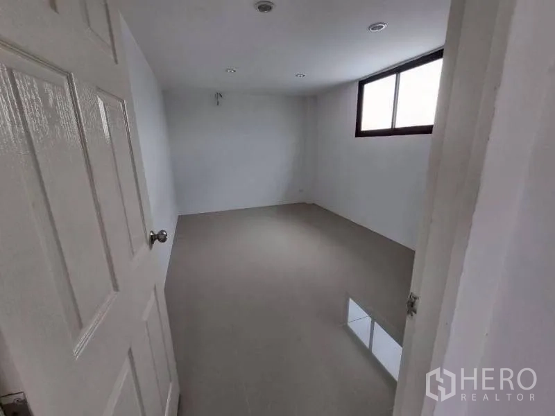 Warehouse for rent in Lam Luk Ka, Pathum Thani - Empty office room with recessed lights and a window.
