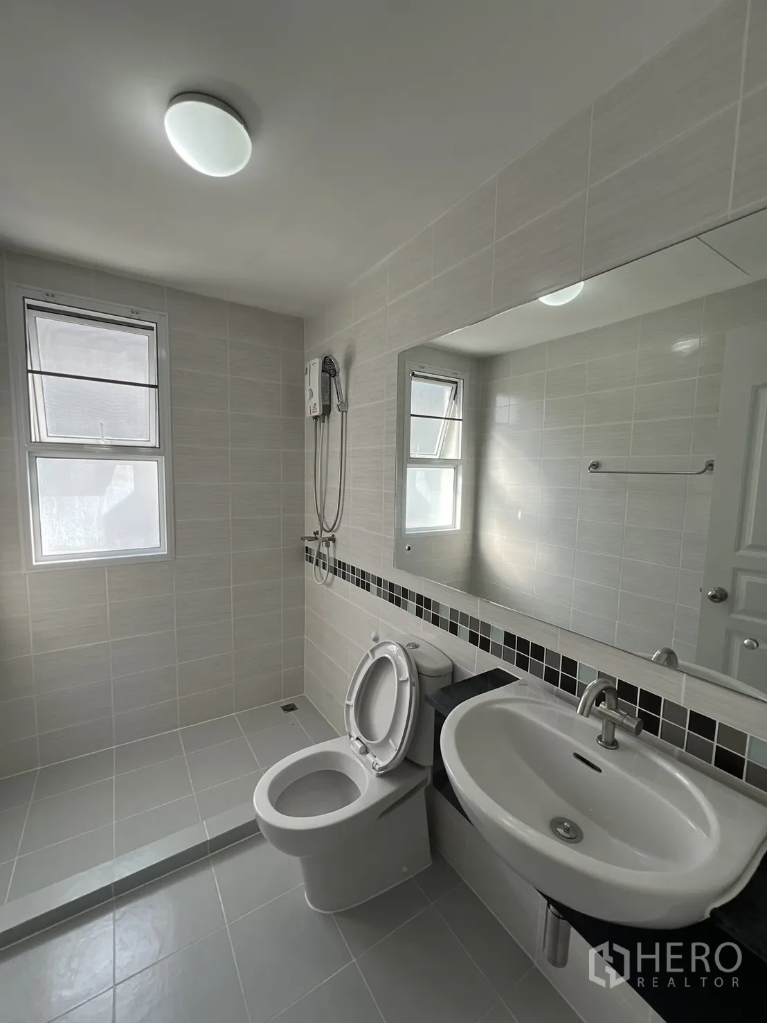 Townhouse for rent in Bang Kapi, Bangkok - Bright bathroom with walk-in shower, toilet and large mirror.