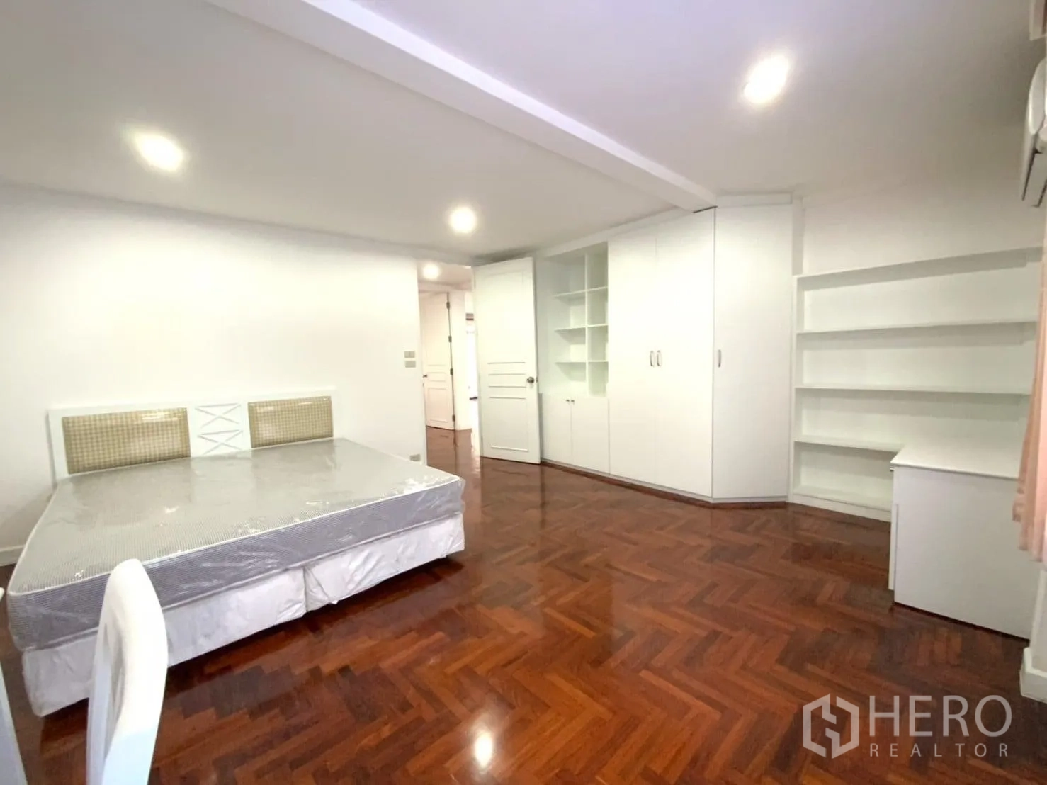 公寓 出租在Watthana, Bangkok - 卧室内壁到壁衣柜与开放搁架，配双人床。