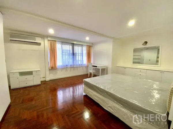 公寓 出租在Watthana, Bangkok - 大卧室配窗户、空调、内置收纳、书桌和拼花地板。