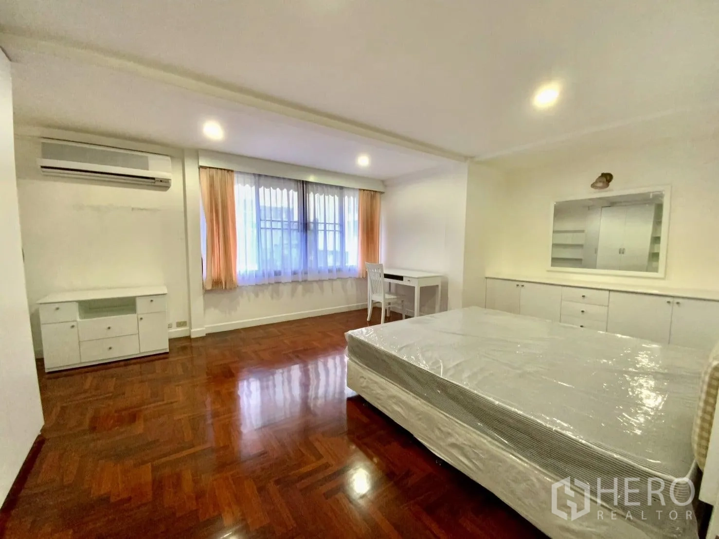 公寓 出租在Watthana, Bangkok - 大卧室配窗户、空调、内置收纳、书桌和拼花地板。
