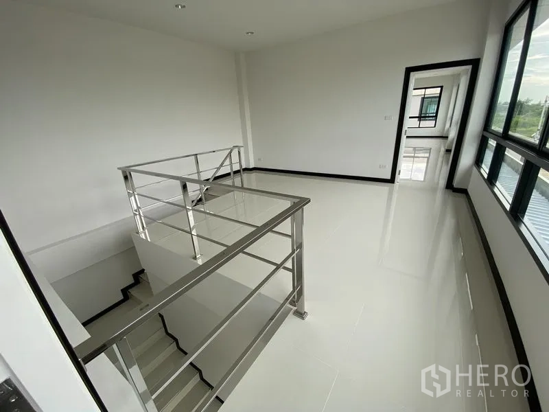 Warehouse for rent or sale in Bang Len, Nakhon Pathom - Bright stair landing with stainless-steel railing and full-height windows.