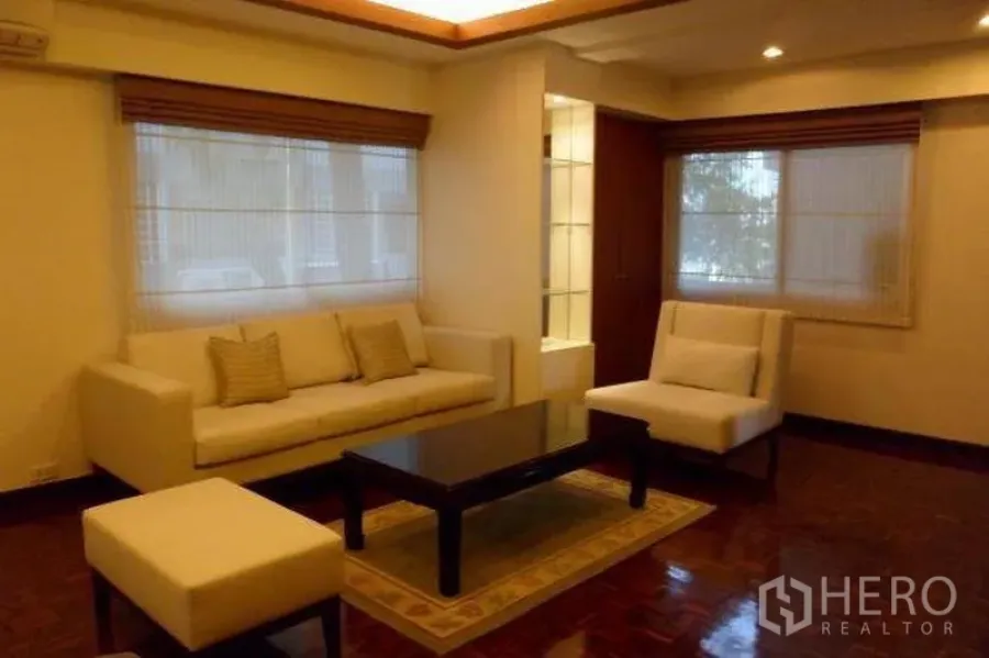 คอนโด ให้เช่าในPathum Wan, Bangkok - ห้องนั่งเล่นโทนอบอุ่น โซฟาสีครีม โต๊ะกลาง ไฟฝ้าซ่อน พร้อมพื้นปาร์เกต์