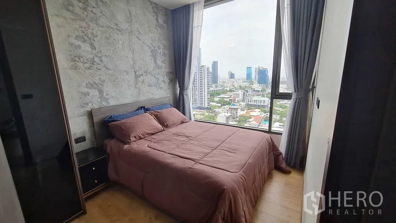 公寓 出租在Watthana, Bangkok - 卧室设大窗，城市景观与质感背景墙。