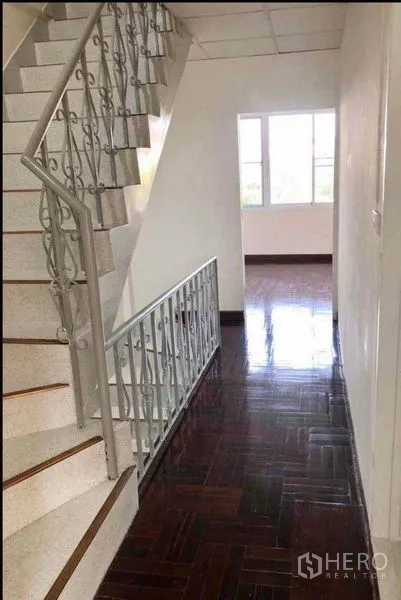 带办公室的家 出租或出售在Watthana, Bangkok - 室内楼梯配金属栏杆，旁有走道通向明亮房间。
