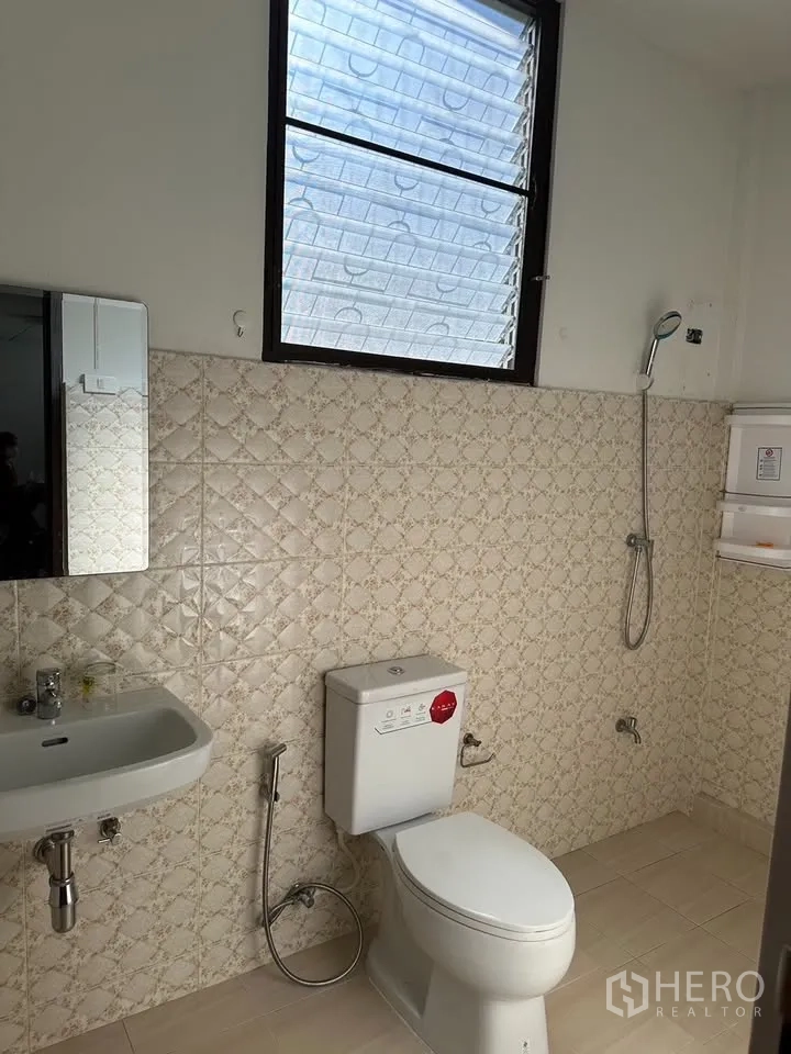 Detached House for rent in Phra Khanong, Bangkok - Light bathroom with cream patterned tiles, window, shower, toilet and basin.