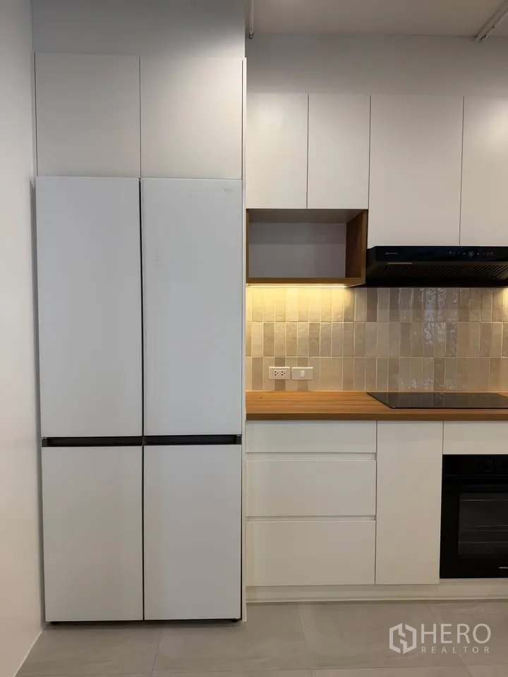 公寓 for rent in Watthana, Bangkok - 高大冰箱、橱柜、炉灶与嵌入式烤箱并列。