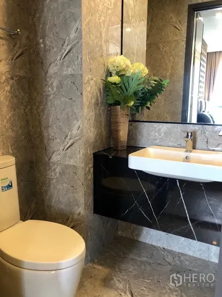 公寓 出租在Watthana, Bangkok - 大理石风格浴室，配洗手台、大镜子与坐便器