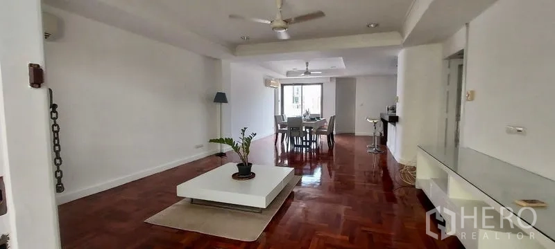 联排别墅 出租在Sathon, Bangkok - 宽敞的开放式客餐厅，抛光木地板与吊扇。
