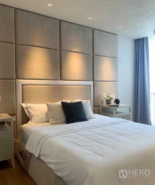 Condominium for rent or sale in Watthana, Bangkok - Bedroom with upholstered wall panels, soft downlights and a double bed.