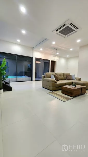 独立式住宅 出售在Khlong Toei, Bangkok - 开放式起居空间，瓷砖地面，透过玻璃可见泳池。