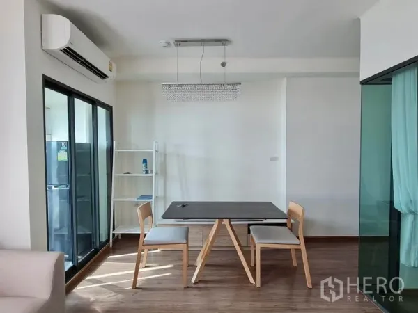 公寓 出租或出售在Yan Nawa, Bangkok - 采光良好的用餐角，双人餐桌、水晶吊灯，旁连推拉玻璃门与厨房。