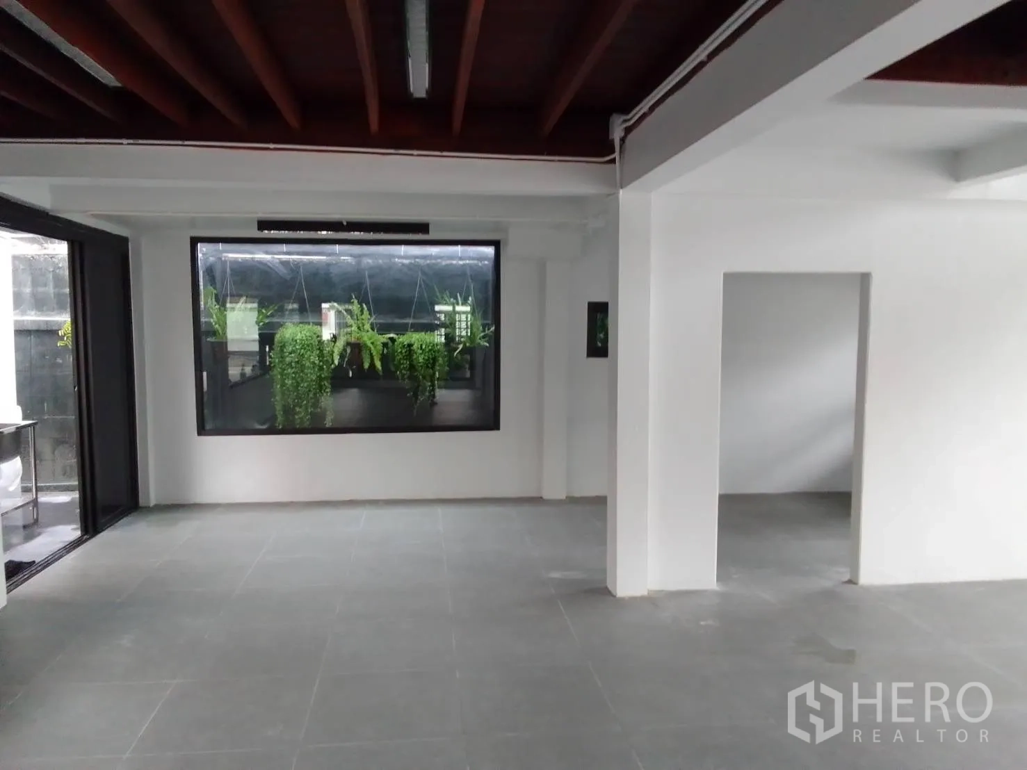 带办公室的家 出租在Wang Thonglang, Bangkok - 一层灰色地砖大厅，窗外可见绿植墙