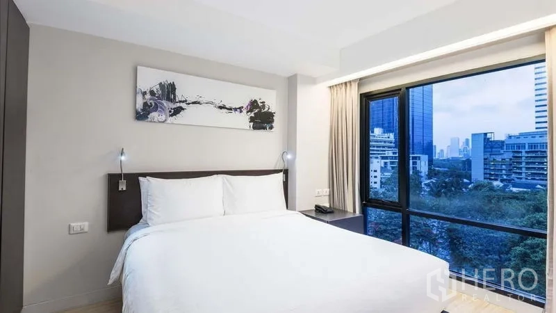 อพาร์ทเมนท์ ให้เช่าในWatthana, Bangkok - ห้องนอนที่สองพร้อมหน้าต่างมุม มองเห็นพื้นที่สีเขียวและอาคารเมือง.