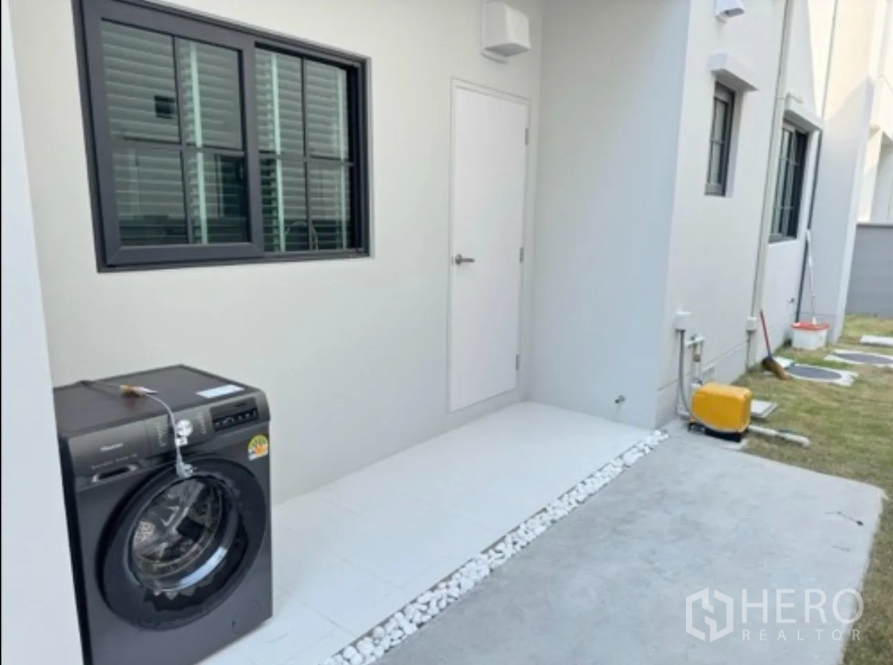 Detached House for rent in Bang Phli, Samut Prakan - Outdoor utility area with washing machine, side walkway and small lawn.