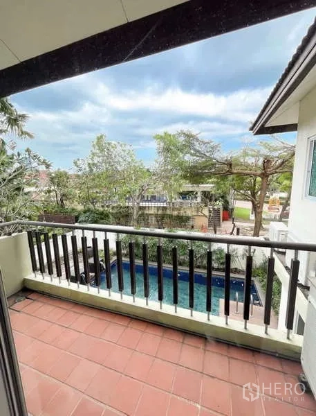 บ้าน ให้เช่าในBang Phli, Samut Prakan - ระเบียงชั้นบนราวสีเข้ม มองเห็นสระว่ายน้ำและวิวต้นไม้