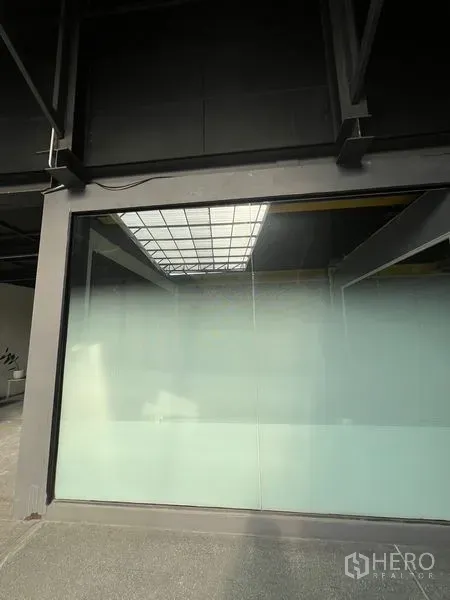 Retail Space for rent in Watthana, Bangkok - Modern retail unit with large frosted glass storefront and steel frame reflecting a skylight.