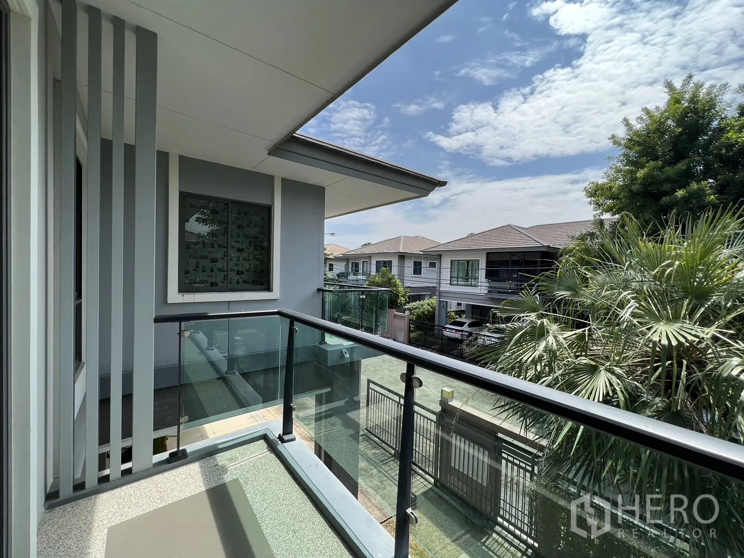 Detached House for sale in Suan Luang, Bangkok - Glass-railed balcony overlooking quiet tree-lined street.