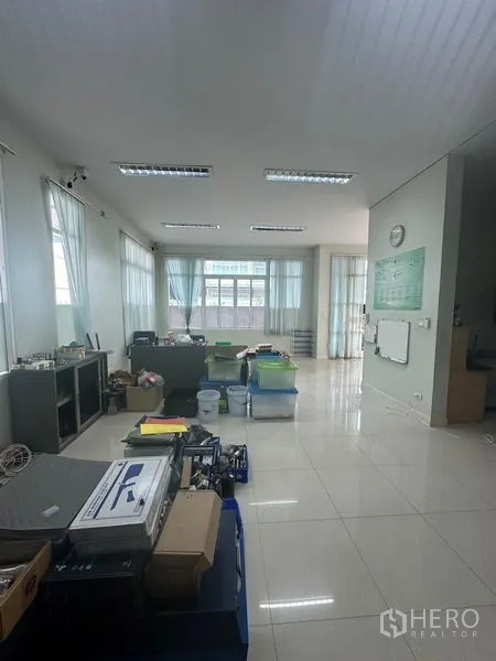 Warehouse for rent or sale in Lam Luk Ka, Pathum Thani - Spacious open‑plan office area with wide windows, tile floor and storage.