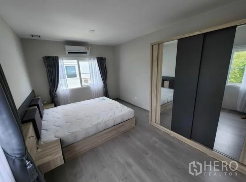 独立式住宅 出租在Prawet, Bangkok - 卧室配双人床、镜面推拉衣柜、空调和双窗采光。