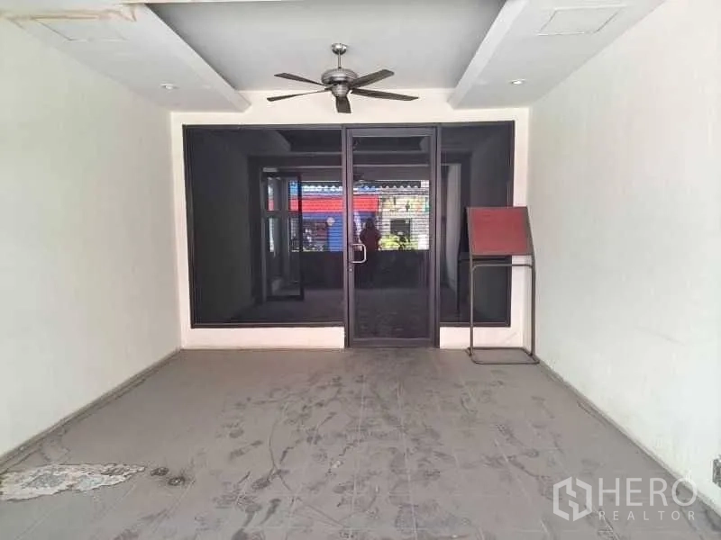 Retail Space for rent - Empty front room with glass doors and a ceiling fan, ideal for reception or display.