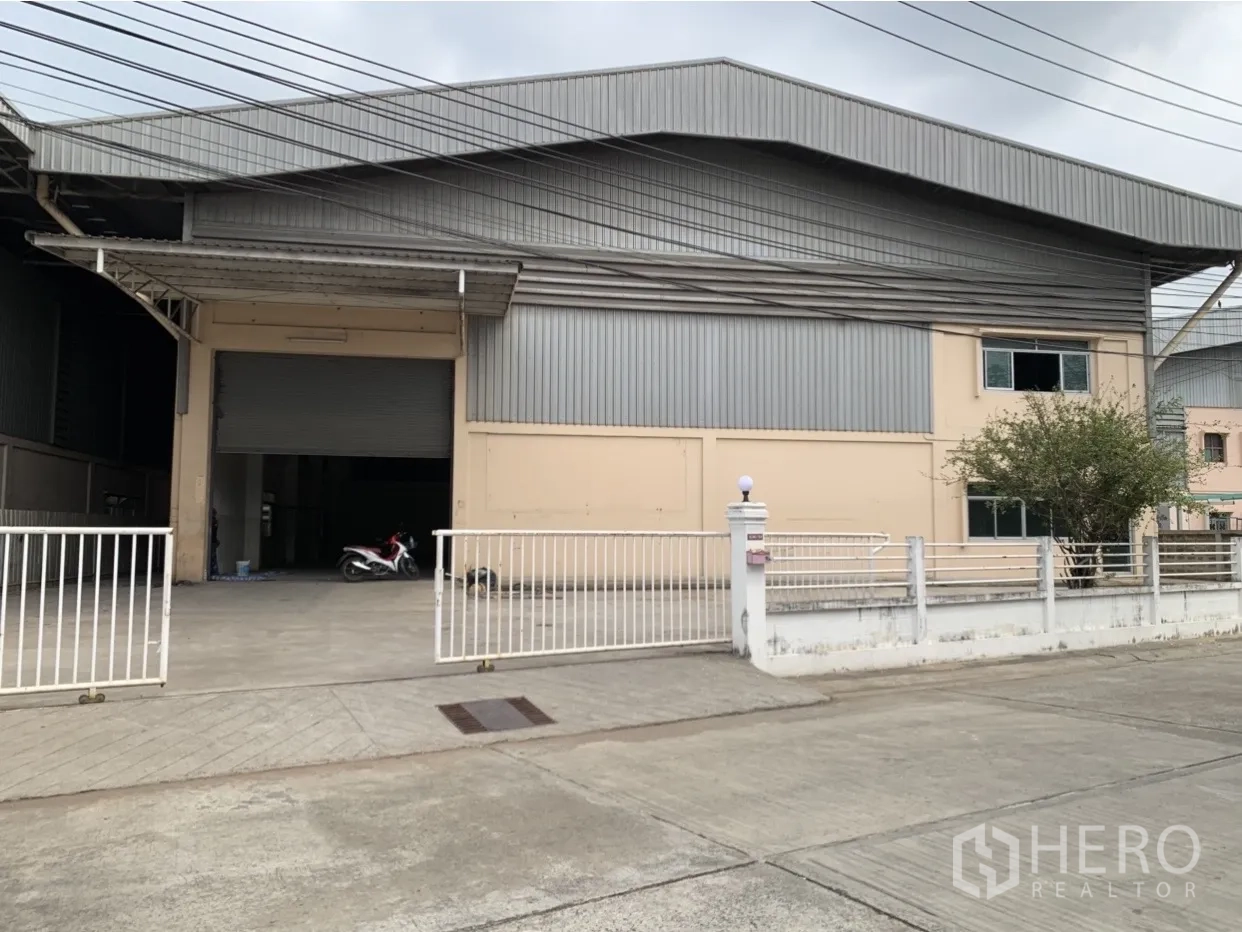 工厂 出租在Mueang Samut Prakan, Samut Prakan - 工厂外立面，金属板结构，带大门与宽敞车道及遮雨装卸区。