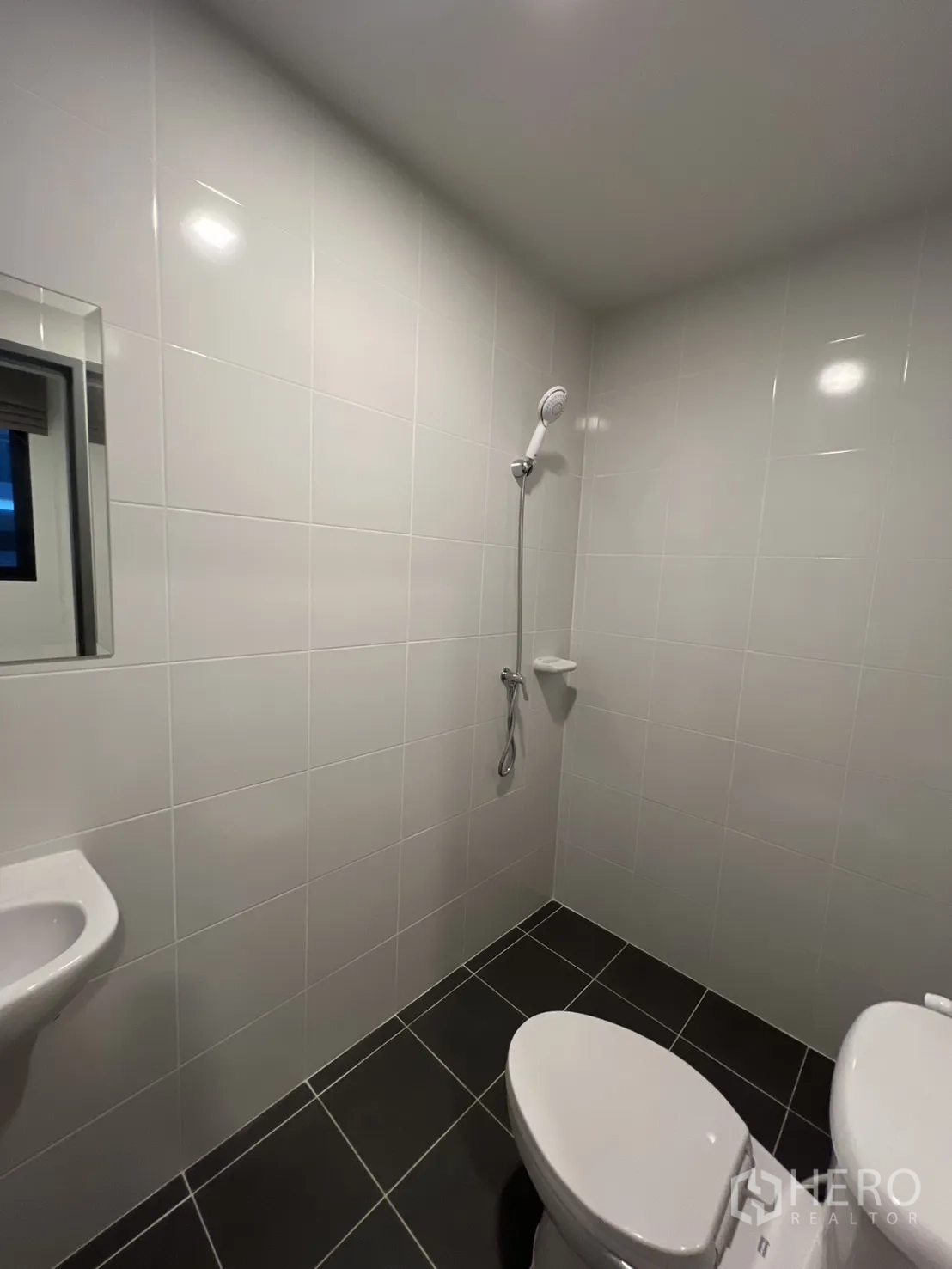 Detached House for rent in Bang Phli, Samut Prakan - Maid’s bathroom with white tiles, toilet and handheld shower.