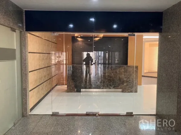 办公空间 出租 - 无框玻璃大门入口，内设大理石接待台的商业楼前厅。