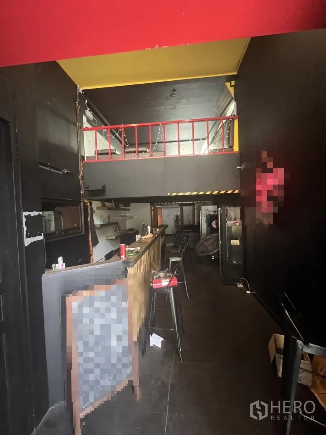 店屋 出租在Khlong Toei, Bangkok - 一层室内带长吧台与高脚椅，顶部为工业风深色天花及夹层
