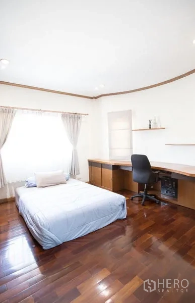 Detached House for sale in Lat Krabang, Bangkok - Secondary bedroom with large window, built-in corner desk and wood floors.