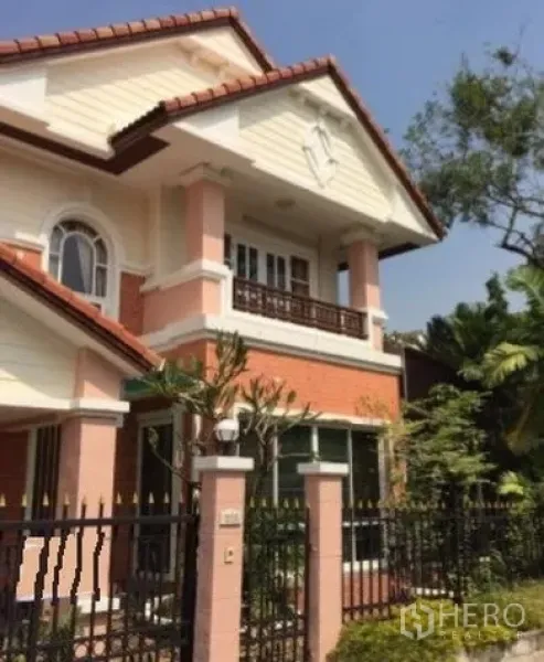 Detached House for rent in Suan Luang, Bangkok - Gated two-storey detached house with gable roof, front balcony and tropical landscaping.