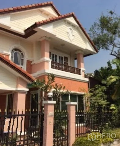 Detached House for rent in Suan Luang, Bangkok - Gated two-storey detached house with gable roof, front balcony and tropical landscaping.