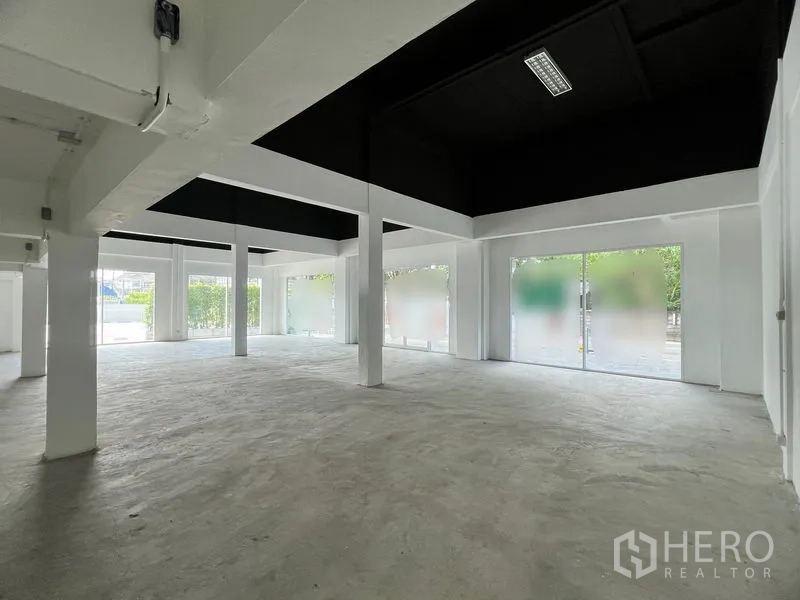 Retail Space for rent in Huai Khwang, Bangkok - Corner retail space with black accent ceiling and multiple glass storefronts.