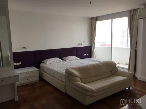 公寓 出租在Watthana, Bangkok - 宽敞主卧，带阳台城市景观与沙发座。