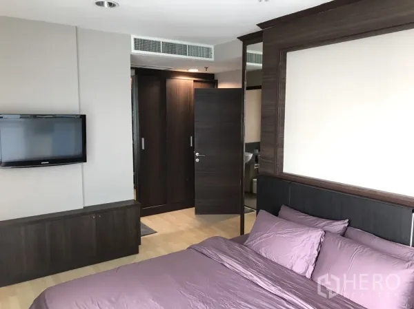 คอนโด ให้เช่าในWatthana, Bangkok - ห้องนอนหลักพร้อมตู้เสื้อผ้าบิวท์อิน ทีวีติดผนัง และทางเชื่อมเข้าห้องน้ำ
