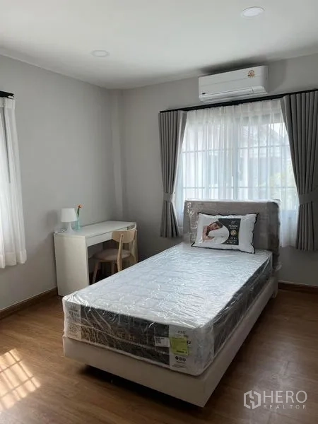 独立式住宅 出租在Bang Phli, Samut Prakan - 采光卧室，单人床、书桌与壁挂空调。