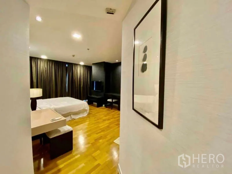 Condominium for rent or sale in Sathon, Bangkok - Hallway leading to bedroom with study nook and floor-length curtains.